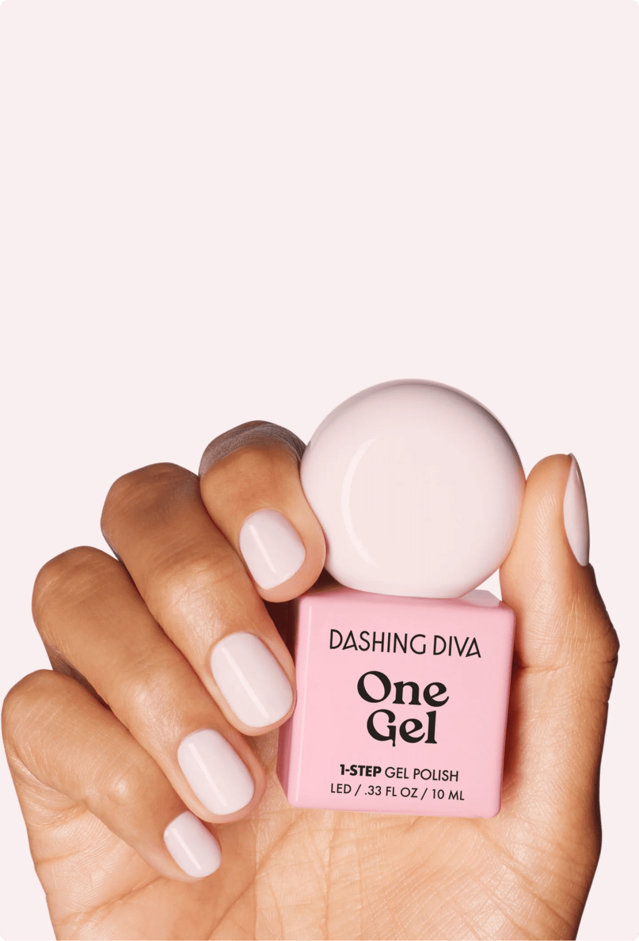Hand holding a pink bottle of Dashing Diva One Gel 1-Step Gel Polish with matching sheer pink manicure
